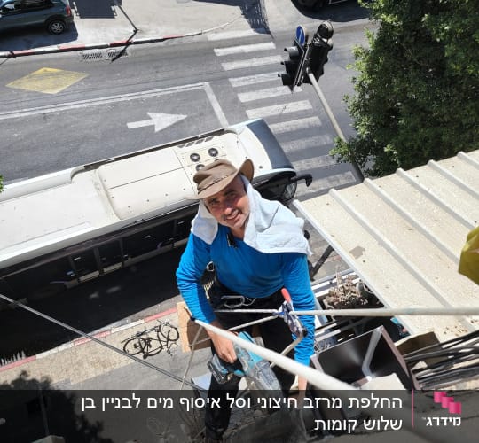 אדם עובד על גג עם כלי עבודה וחבלים